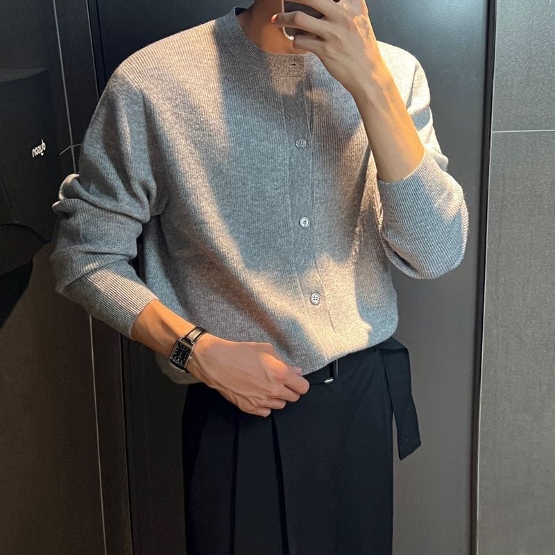 Men’s cardigan with circular neckline, ribbed hem, and long sleeves, worn by model
