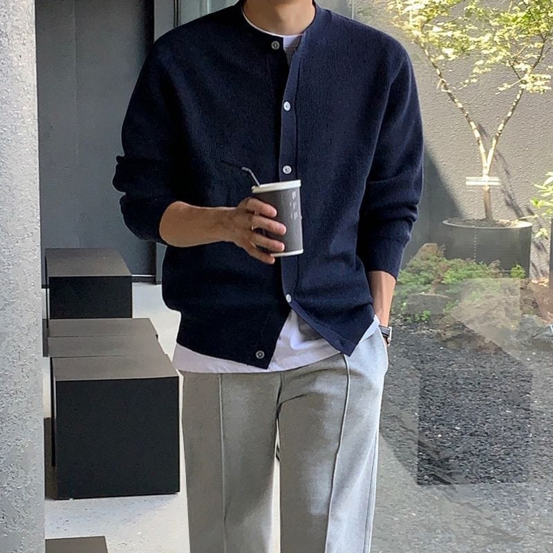 Men’s cardigan with circular neckline, ribbed hem, and long sleeves, worn by model