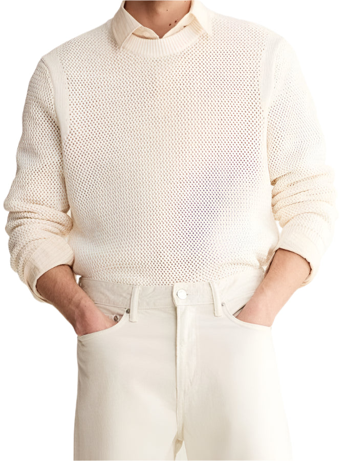 Model wearing knit pullover sweater with ribbed cuffs and round neckline