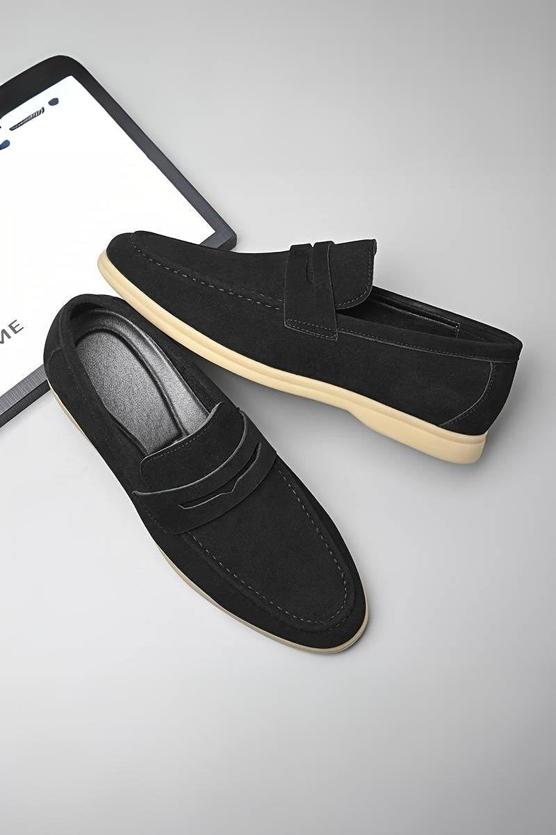 Pair of slip-on loafers with stitched vamp and flat sole, laid flat