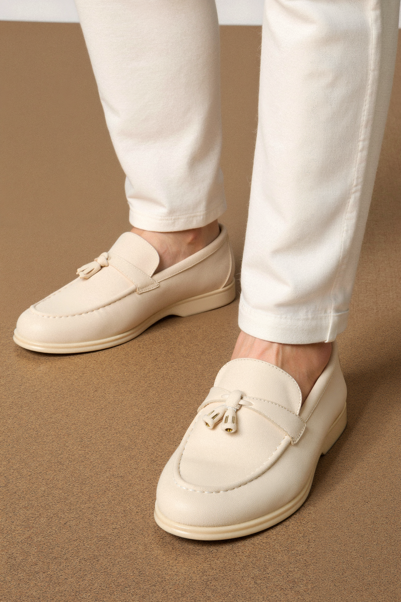 Model wearing tassel slip-on loafers with rounded toe design